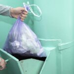 Throwing Garbage Into The Garbage Chute A Man's Hand With