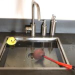 An overflowing sink with a rubber ducky