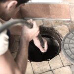 A plumber performs hydro jetting on a sewer line