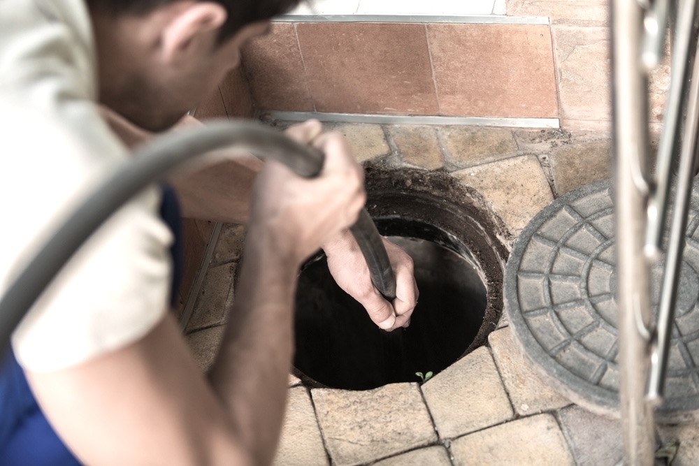 A plumber performs hydro jetting on a sewer line